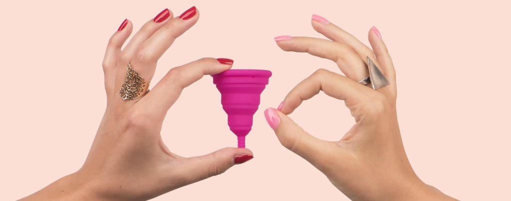 Hands holding menstrual cup.