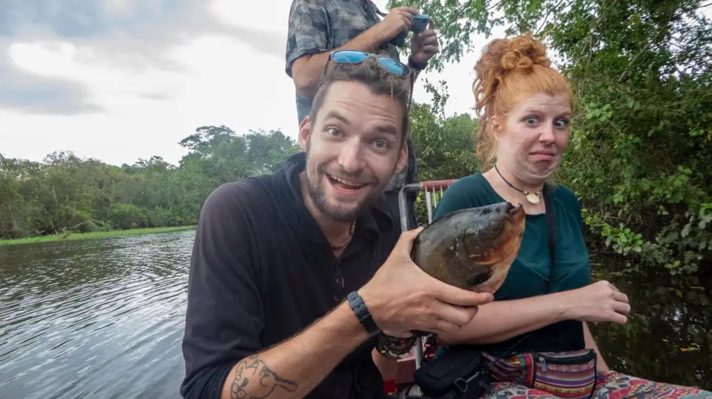 Man holds fish next to scared girl